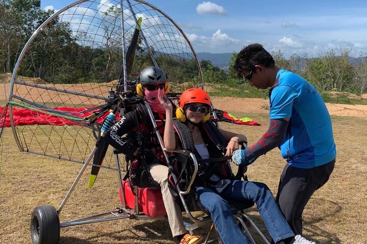 un home empenyent una dona en un carretó amb un paracaigudes