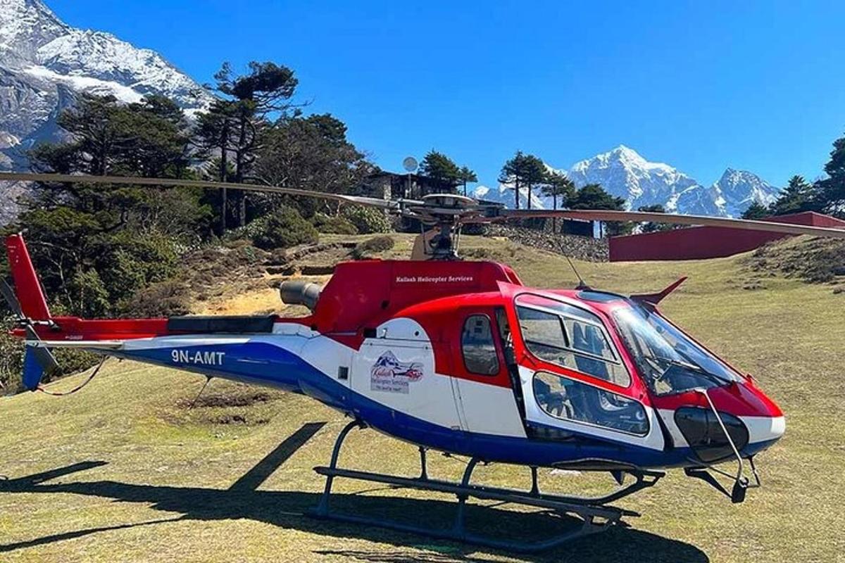 um helicóptero vermelho, branco e azul estacionado em um campo