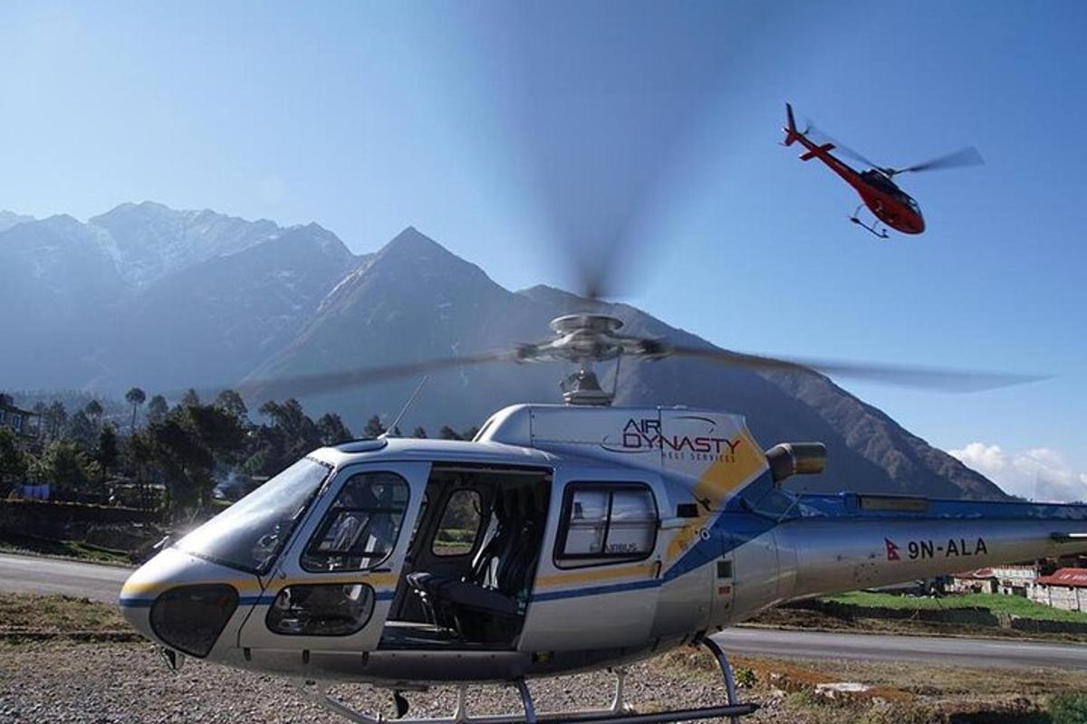um helicóptero pousado em uma pista com montanhas ao fundo