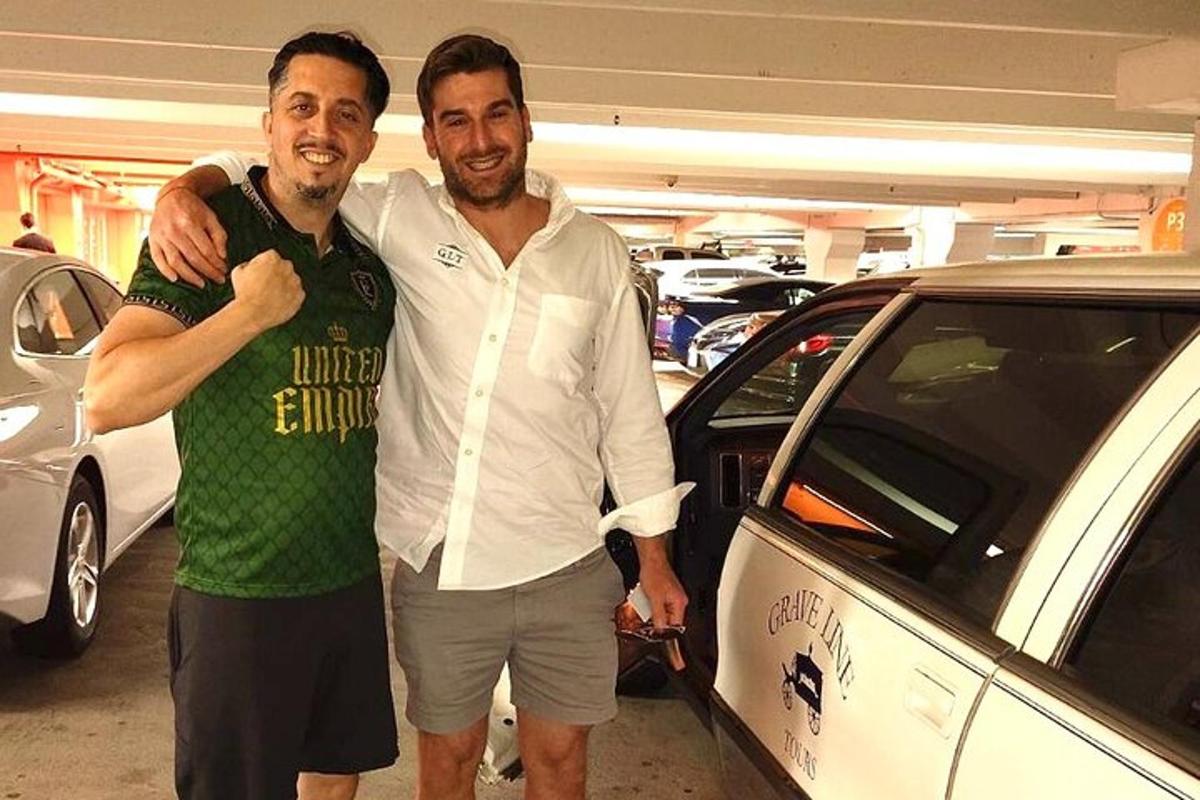 due uomini in piedi accanto a un'auto in un garage
