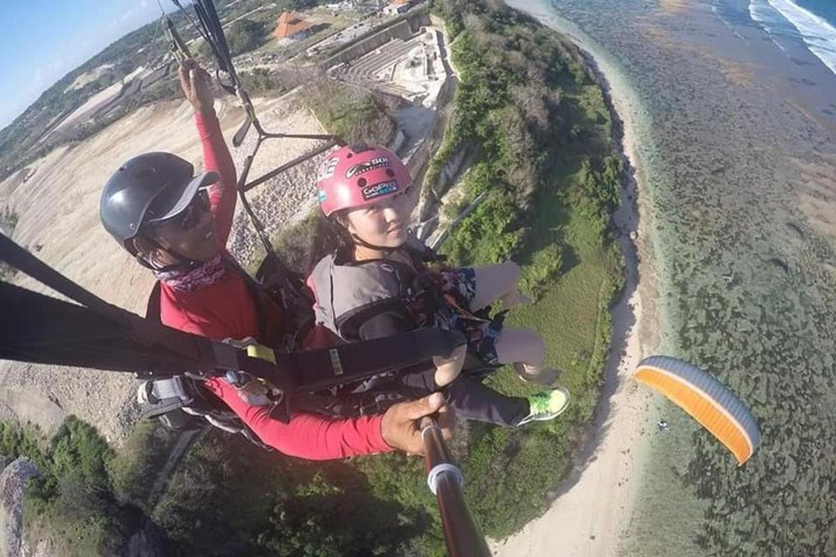 δύο άτομα κάνουν ποδήλατο με αλεξίπτωτο