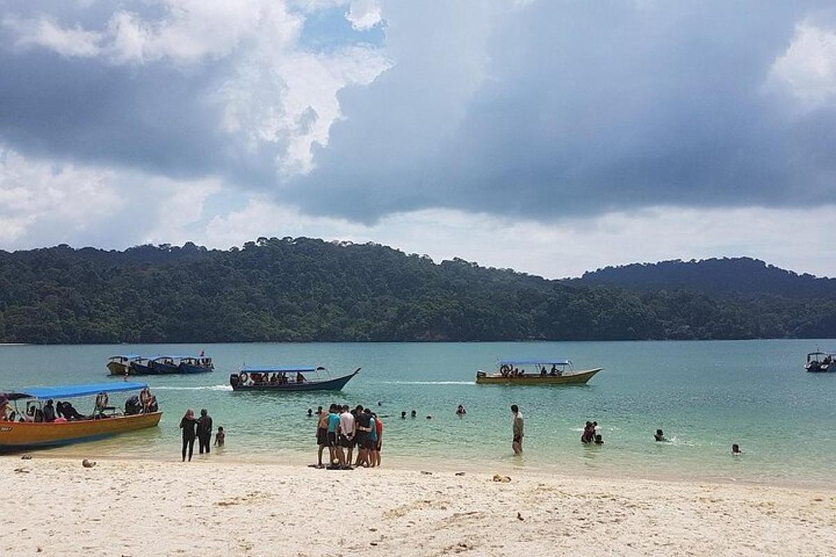 people standing on a beach with boats in the water