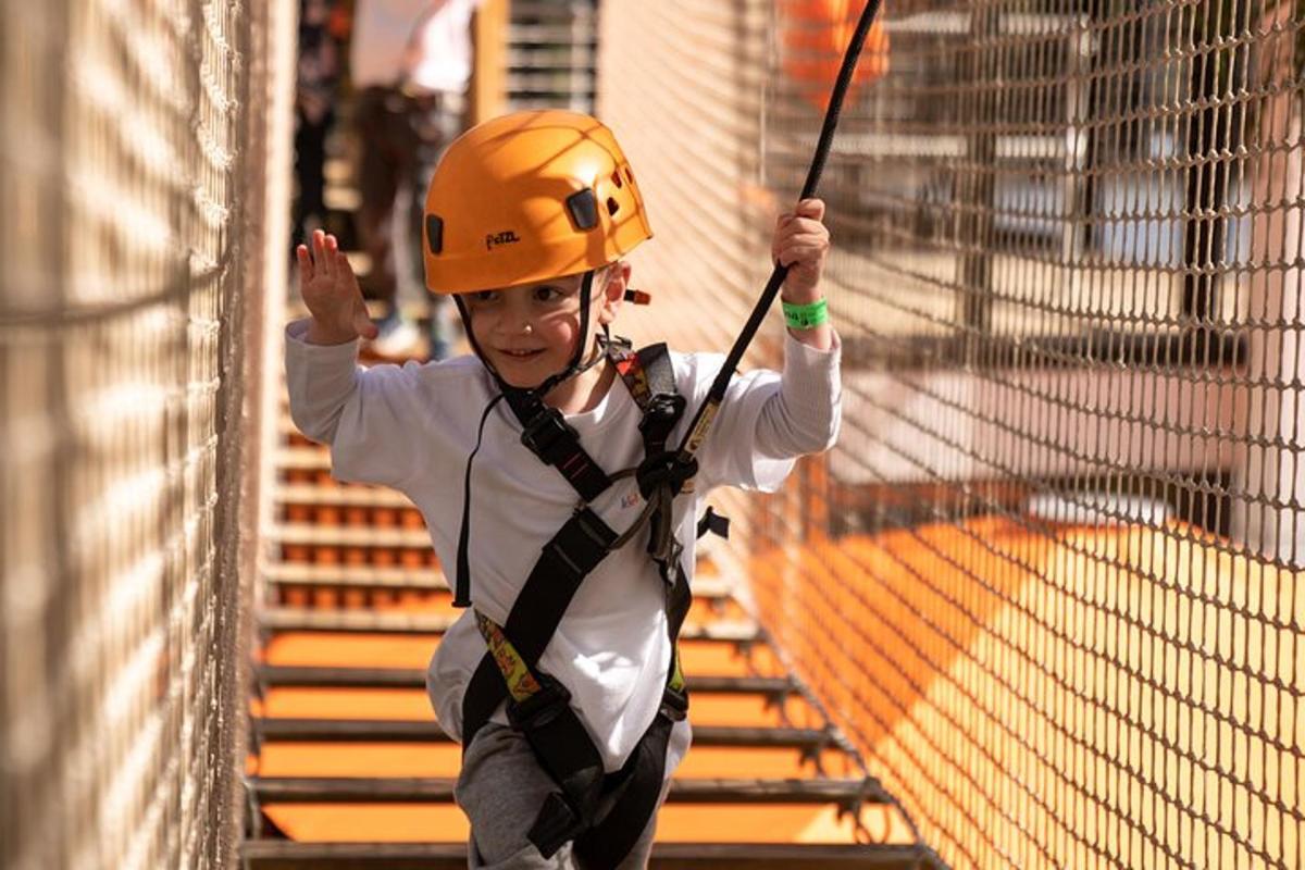 en gutt med oransje hjelm på en zipline