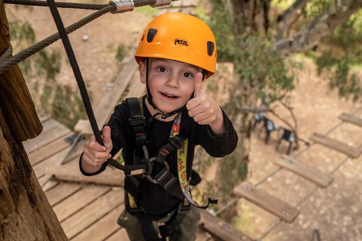 en ung gutt i en oransje hjelm på en zipline