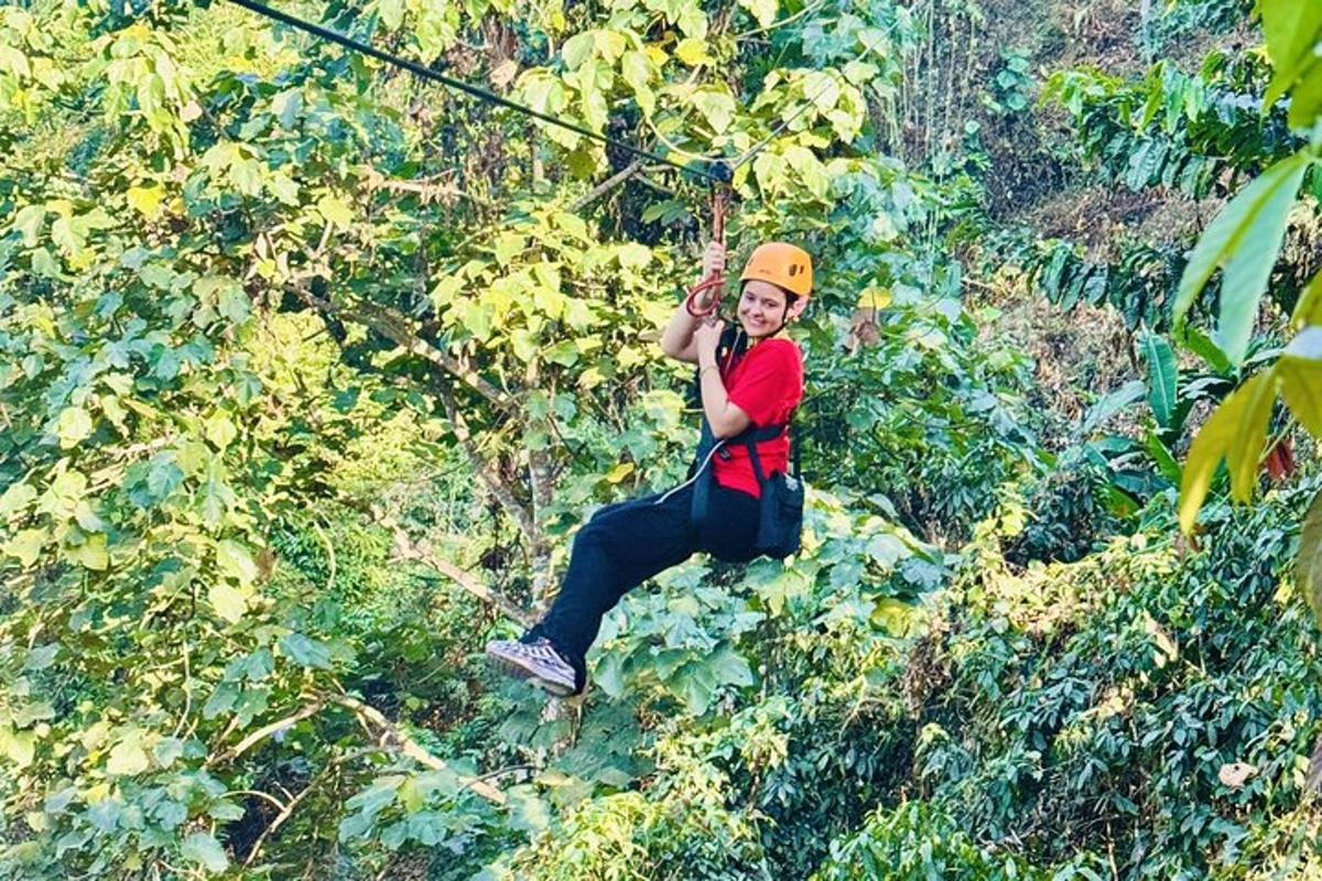 un home pujant a una tirolina a la selva