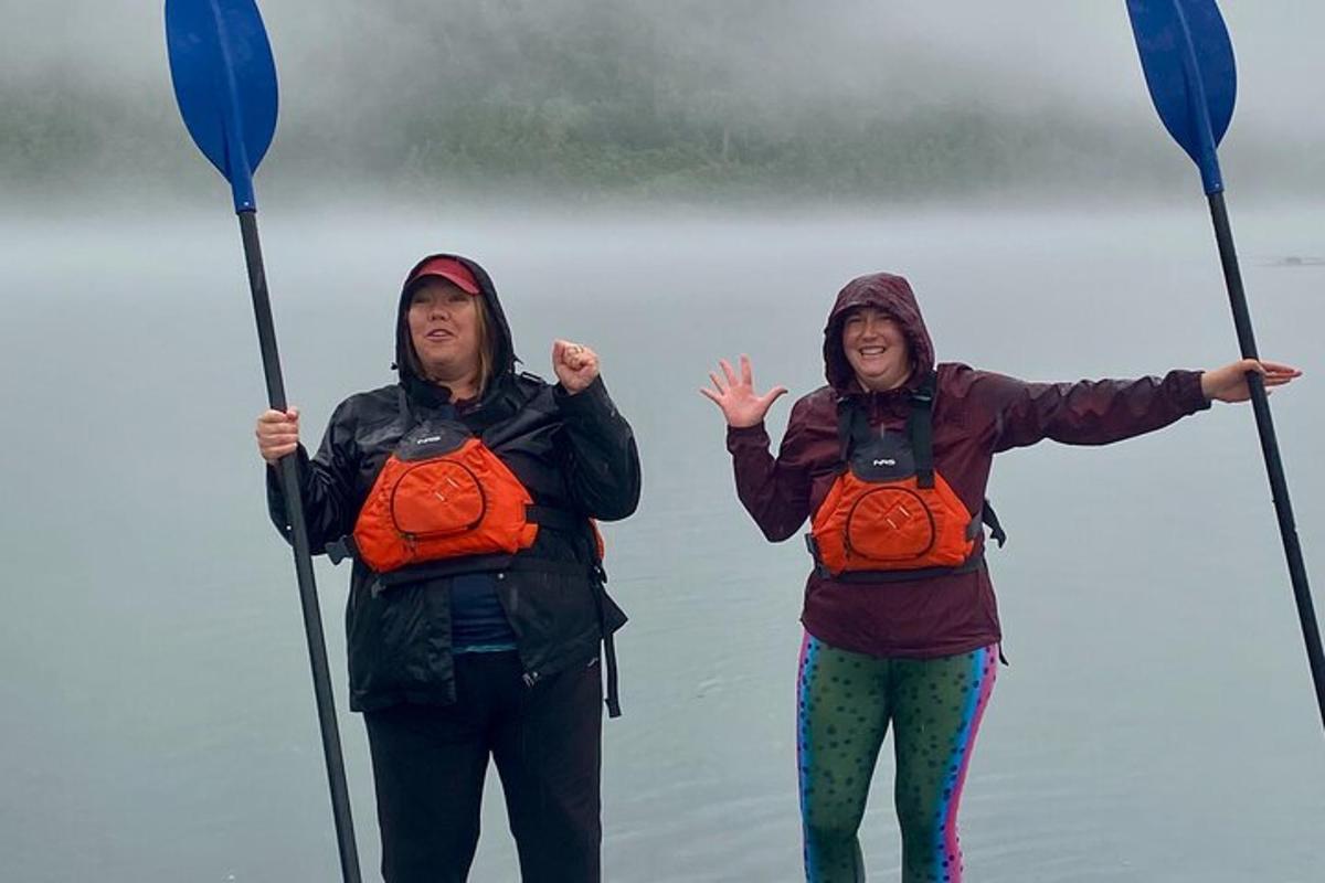Dos mujeres están paradas en el agua con remos.