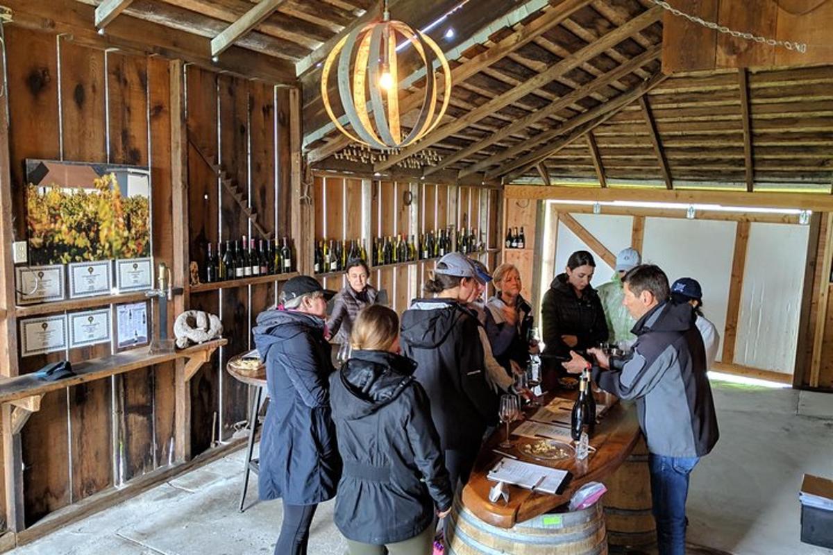 Un grupo de personas de pie alrededor de una sala de cata de vinos.