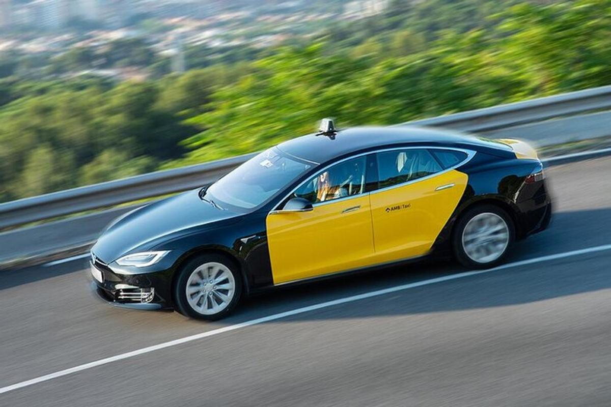 Un coche negro y amarillo circulando por una autopista.