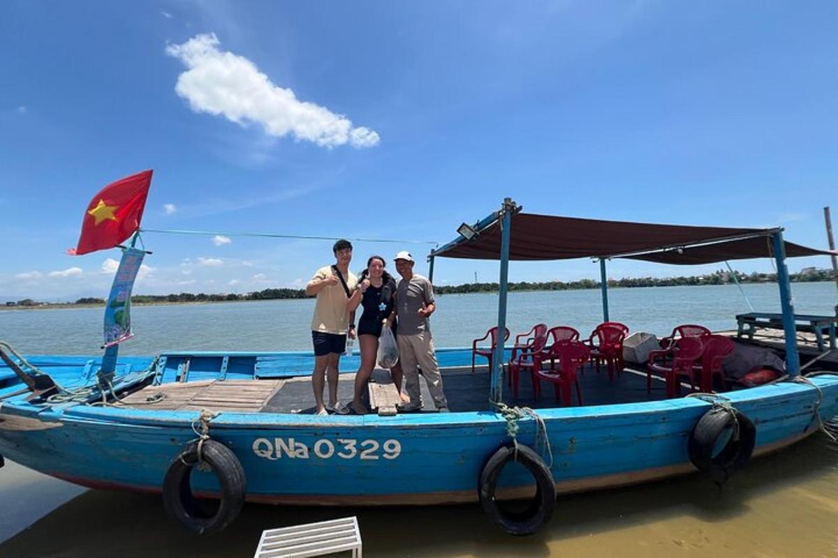 drie mensen staan op een blauwe boot op het water