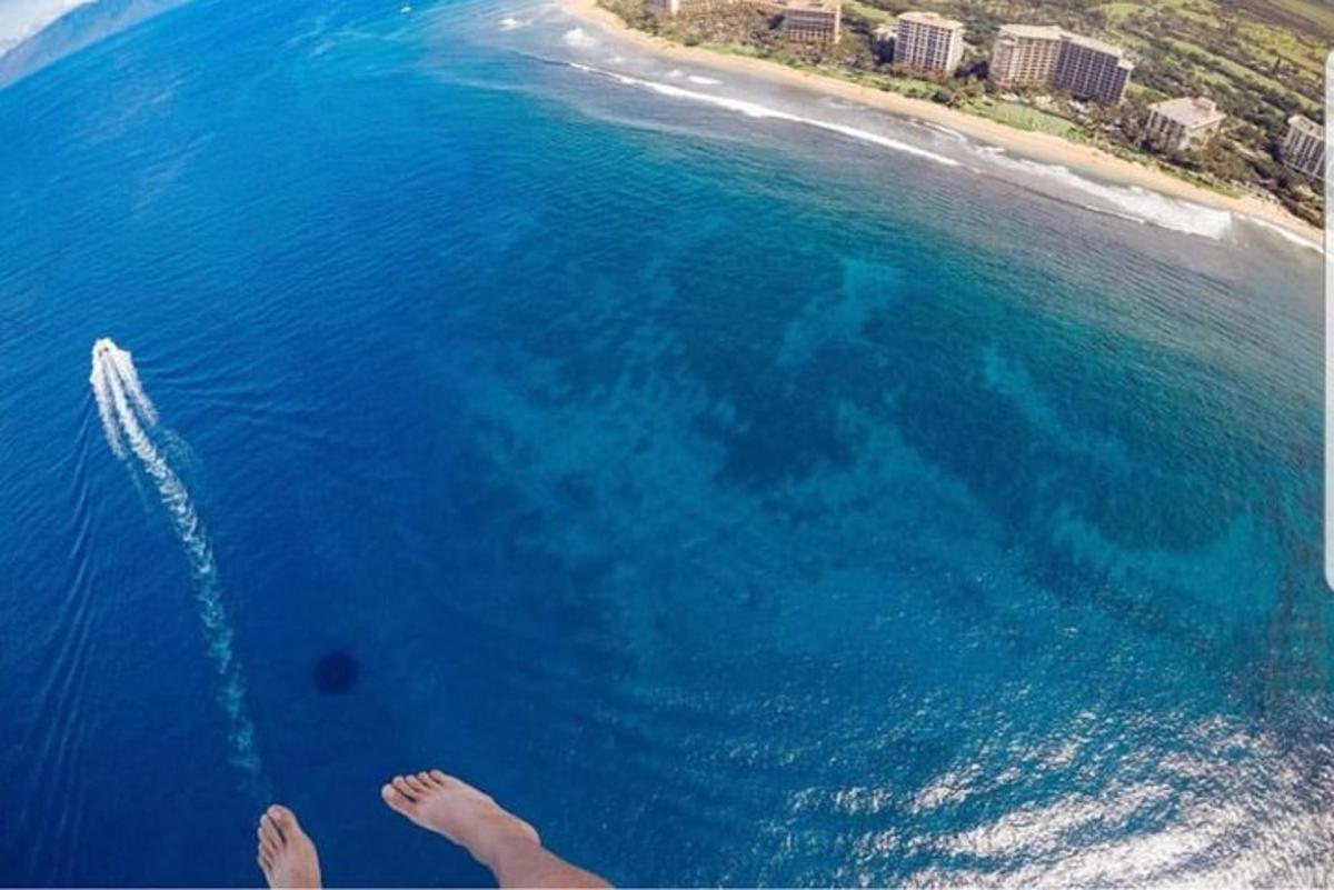 a person flying over the ocean with a boat