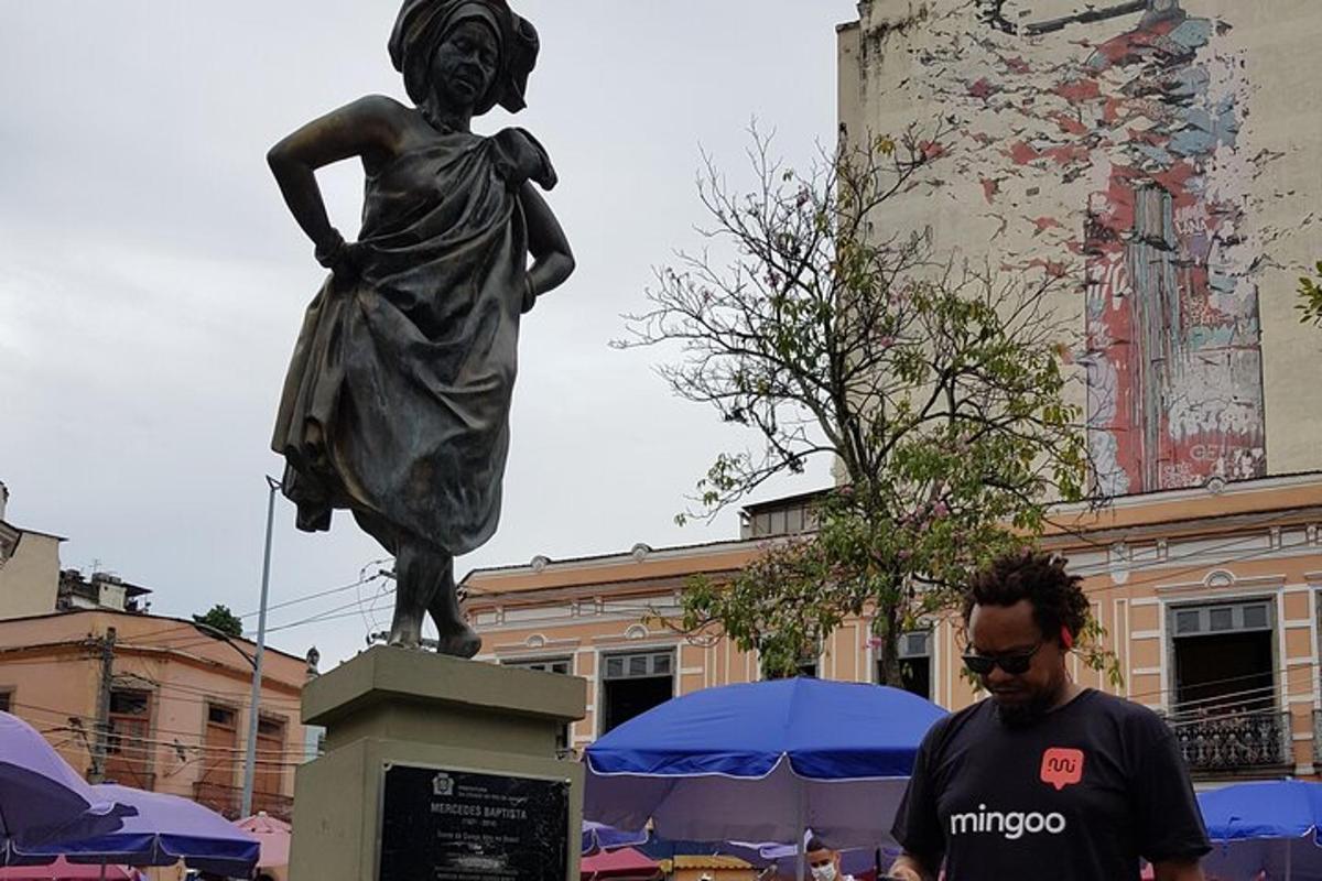 un bărbat care stă lângă o statuie a unei femei