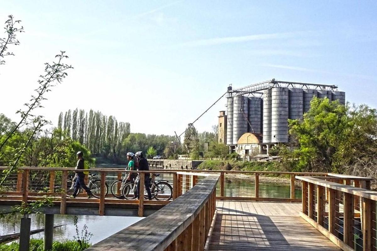 Dos personas andando en bicicleta en un puente sobre un río