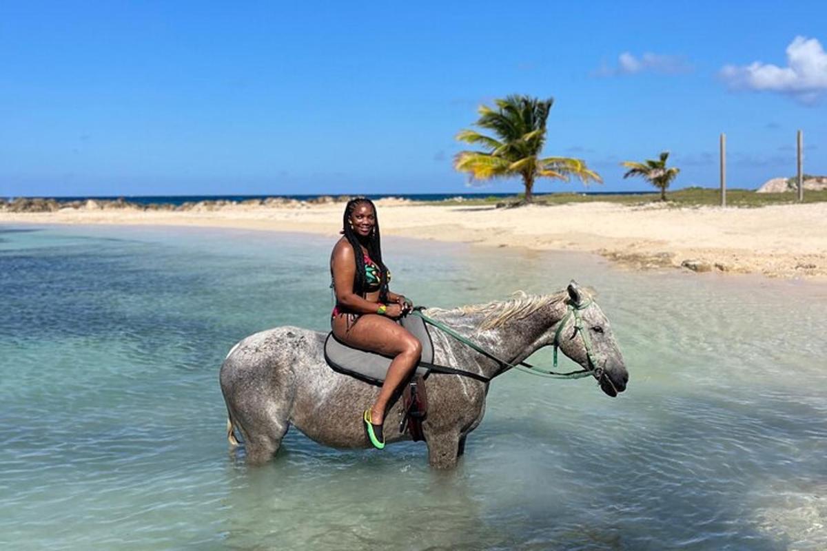 a woman riding a horse on the beach