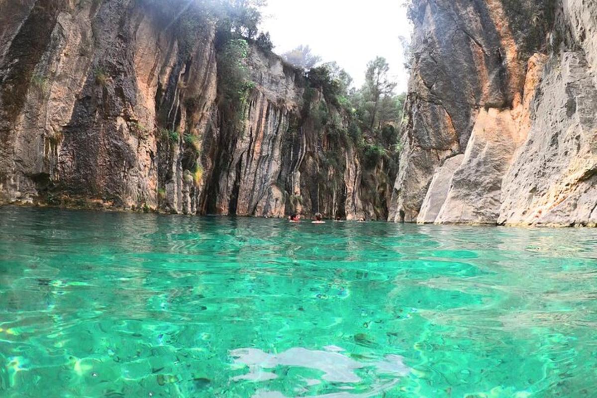 uno specchio d'acqua vicino a una scogliera rocciosa