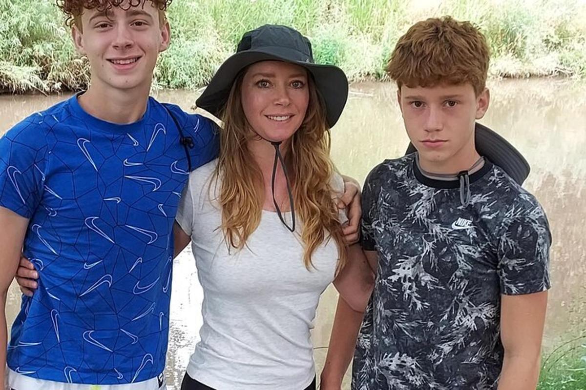 uma menina e dois meninos parados um ao lado do outro