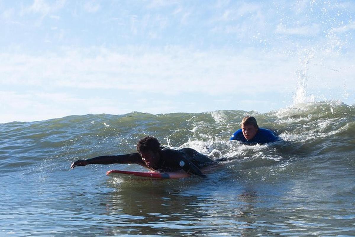 two people riding a wave on a surfboard in the ocean