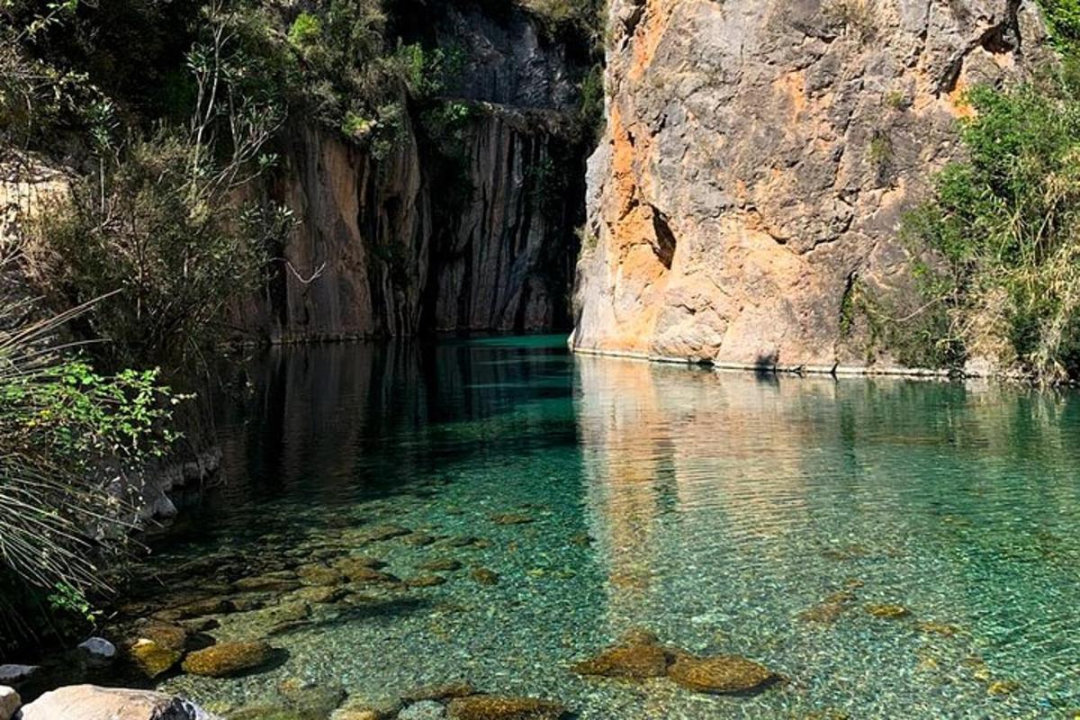 uno specchio d'acqua vicino a una scogliera rocciosa