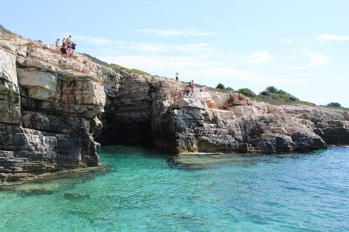 a group of people standing on a cliff in the water