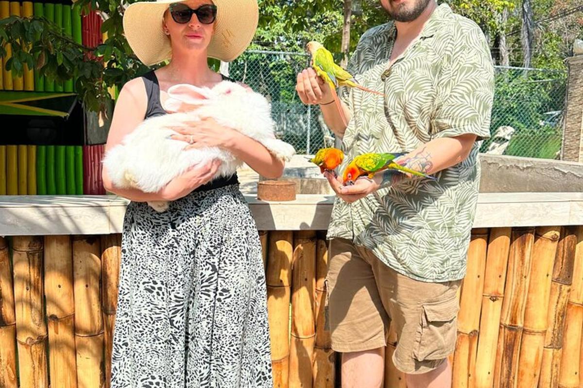 muž a žena držící ptáky v zoo