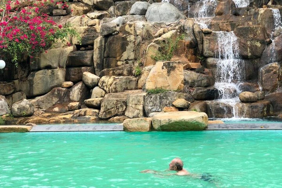 eine Person, die in einem Pool mit einem Wasserfall schwimmt