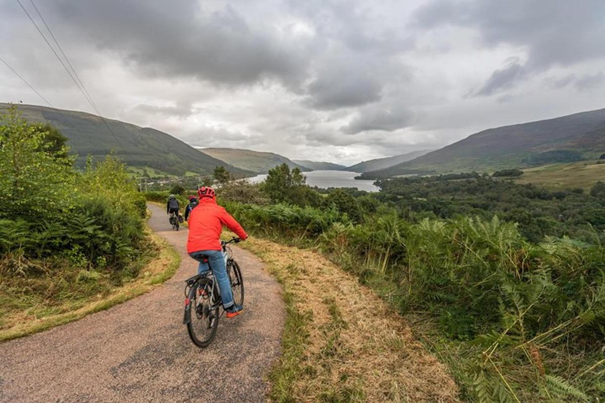 a group of people riding bikes down a dirt road