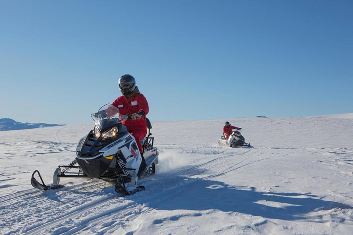 un bărbat merge cu un snowmobil în zăpadă