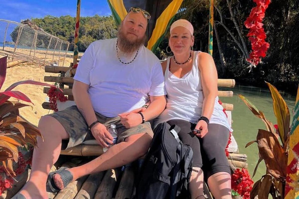 Un hombre y una mujer sentados en un banco en la playa