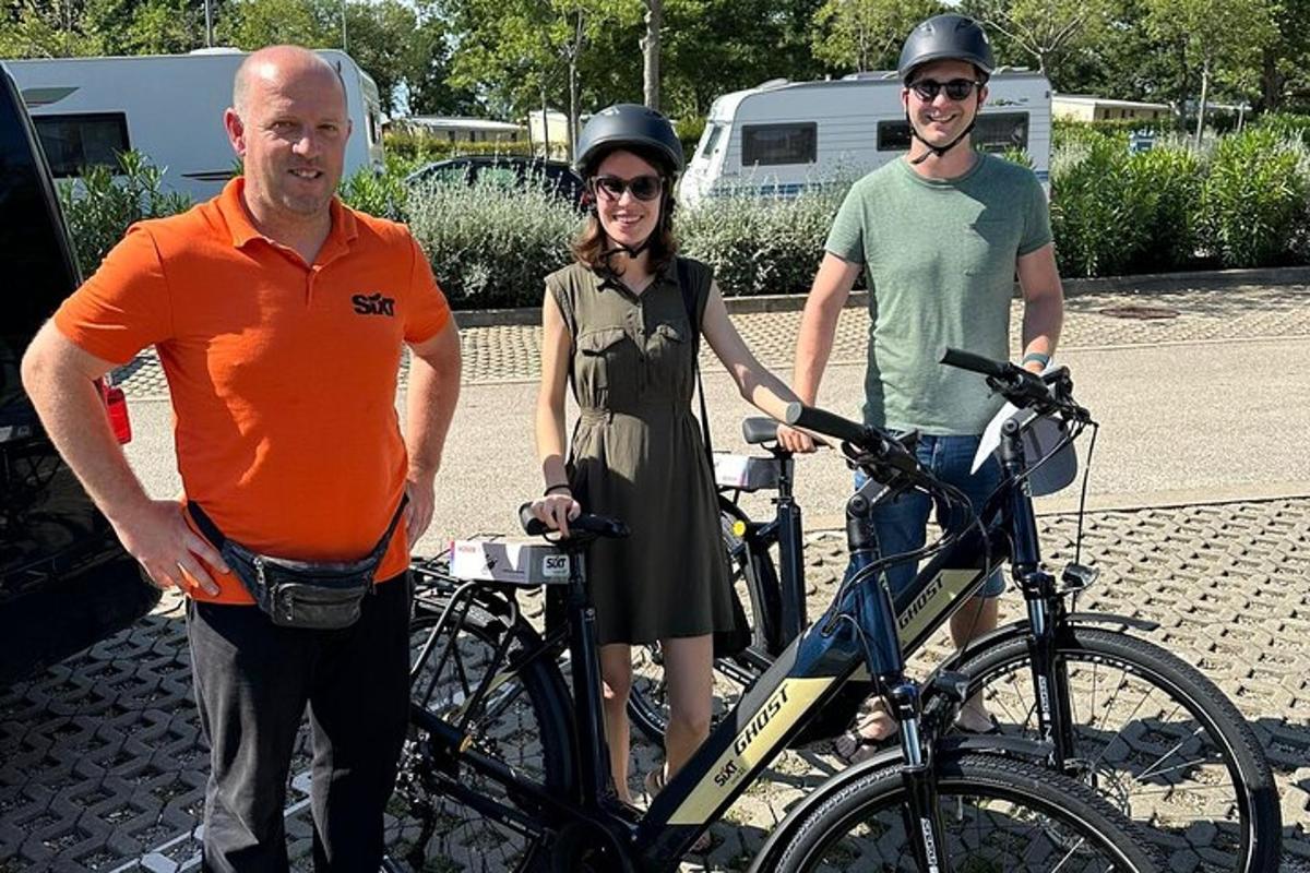 due uomini e una donna in piedi accanto a una bicicletta