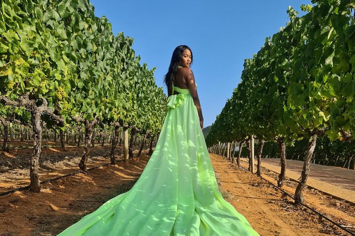 a woman in a green dress in a vineyard