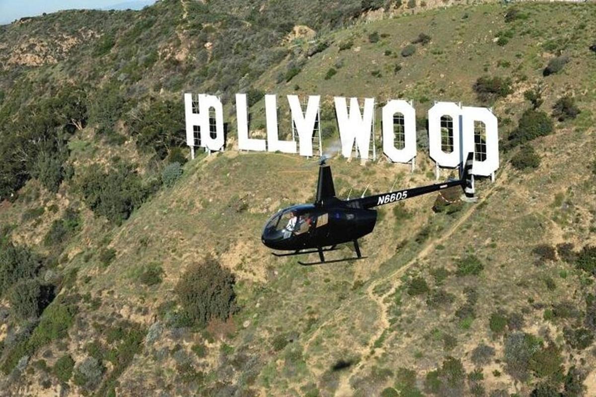malý vrtulník letící před hollywoodskou cedulí