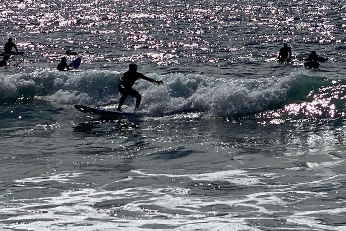 un bărbat călărind un val pe o placă de surf în ocean