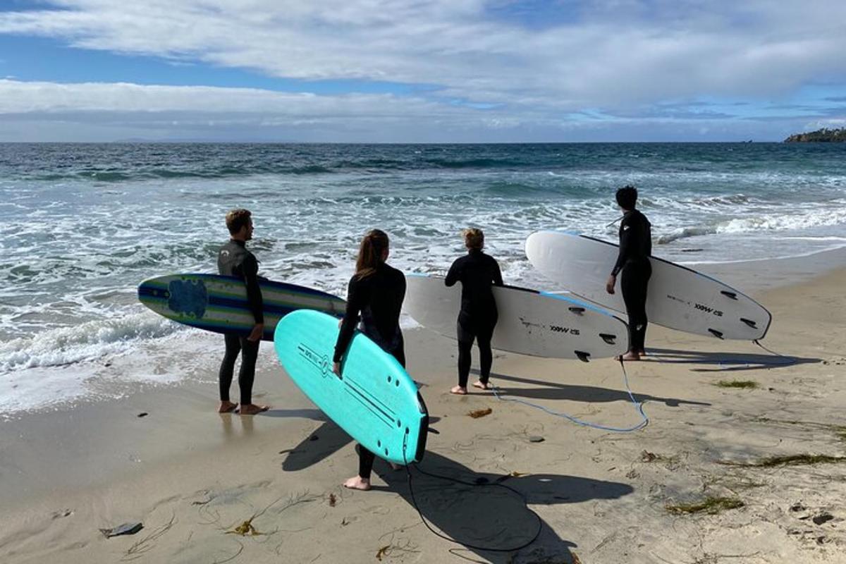 un grup de oameni care stăteau pe plajă cu plăci de surf