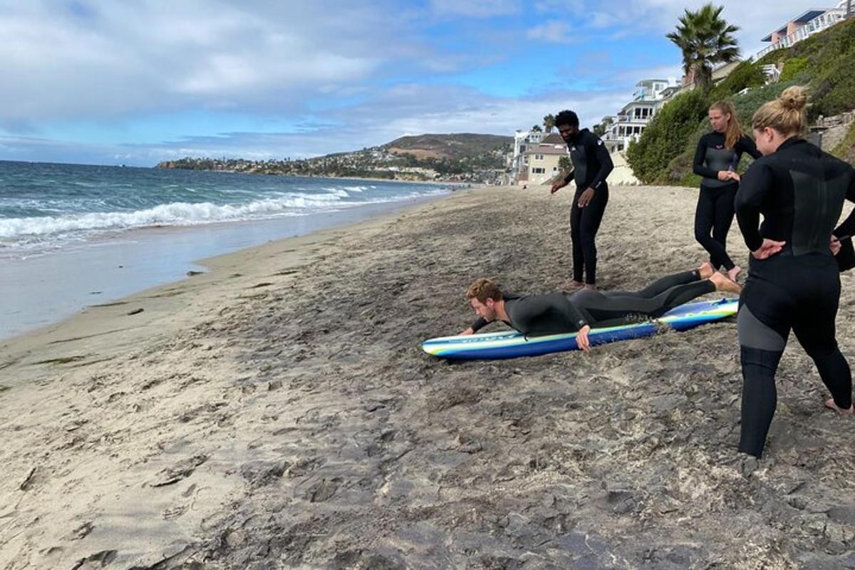 un grup de oameni pe o plajă cu o persoană pe o placă de surf