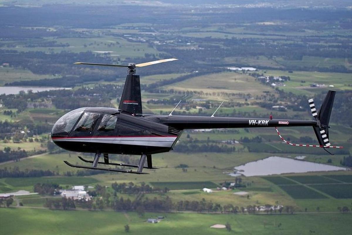 a black helicopter is flying in the air