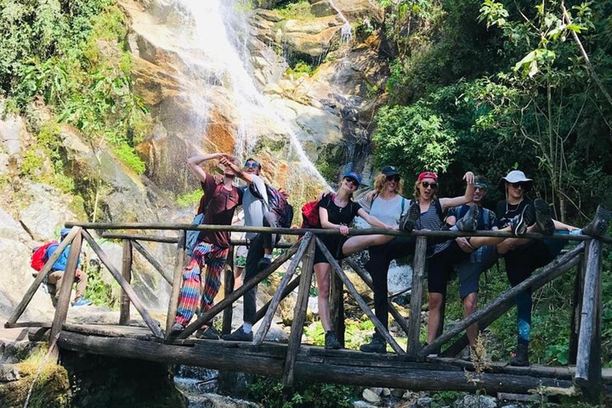 un gruppo di persone sedute su un ponte di fronte a una cascata