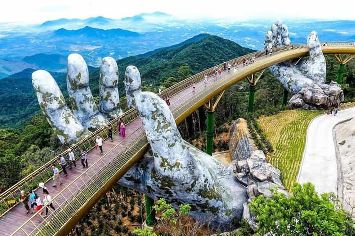 một nhóm người đang đi trên cầu với một bàn tay khổng lồ