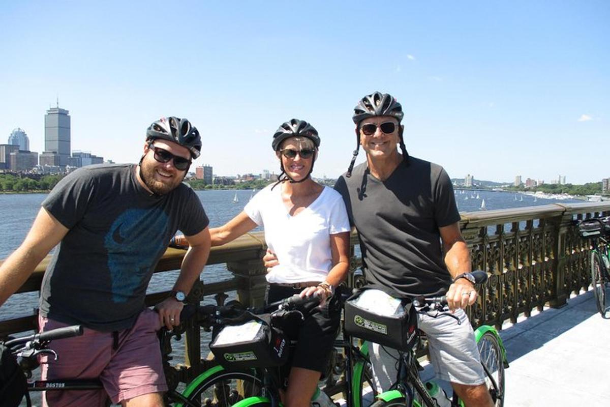 a group of three people with bikes on a bridge