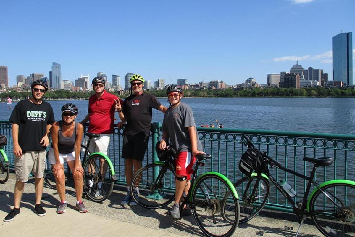 a group of people standing next to their bikes on a bridge
