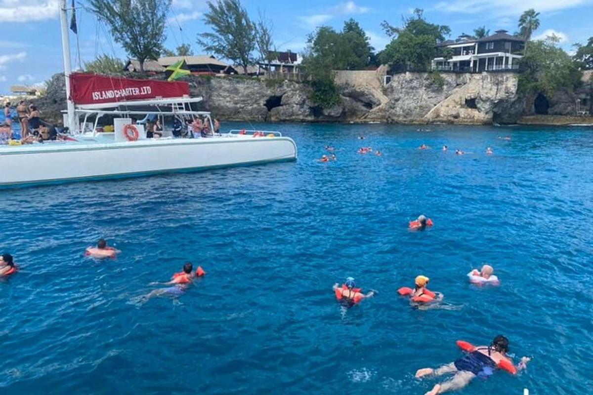 un gruppo di persone che nuotano nell'acqua accanto a una barca
