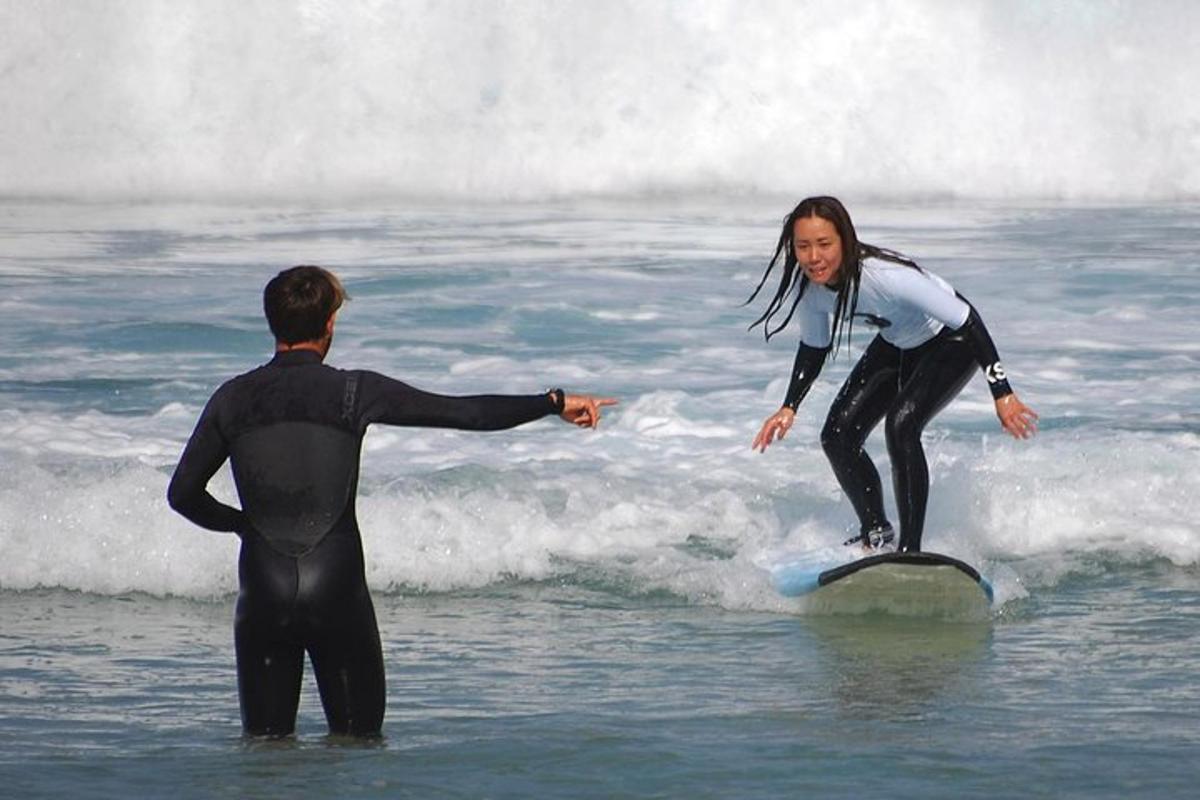 um homem e uma mulher em uma prancha de surfe no oceano