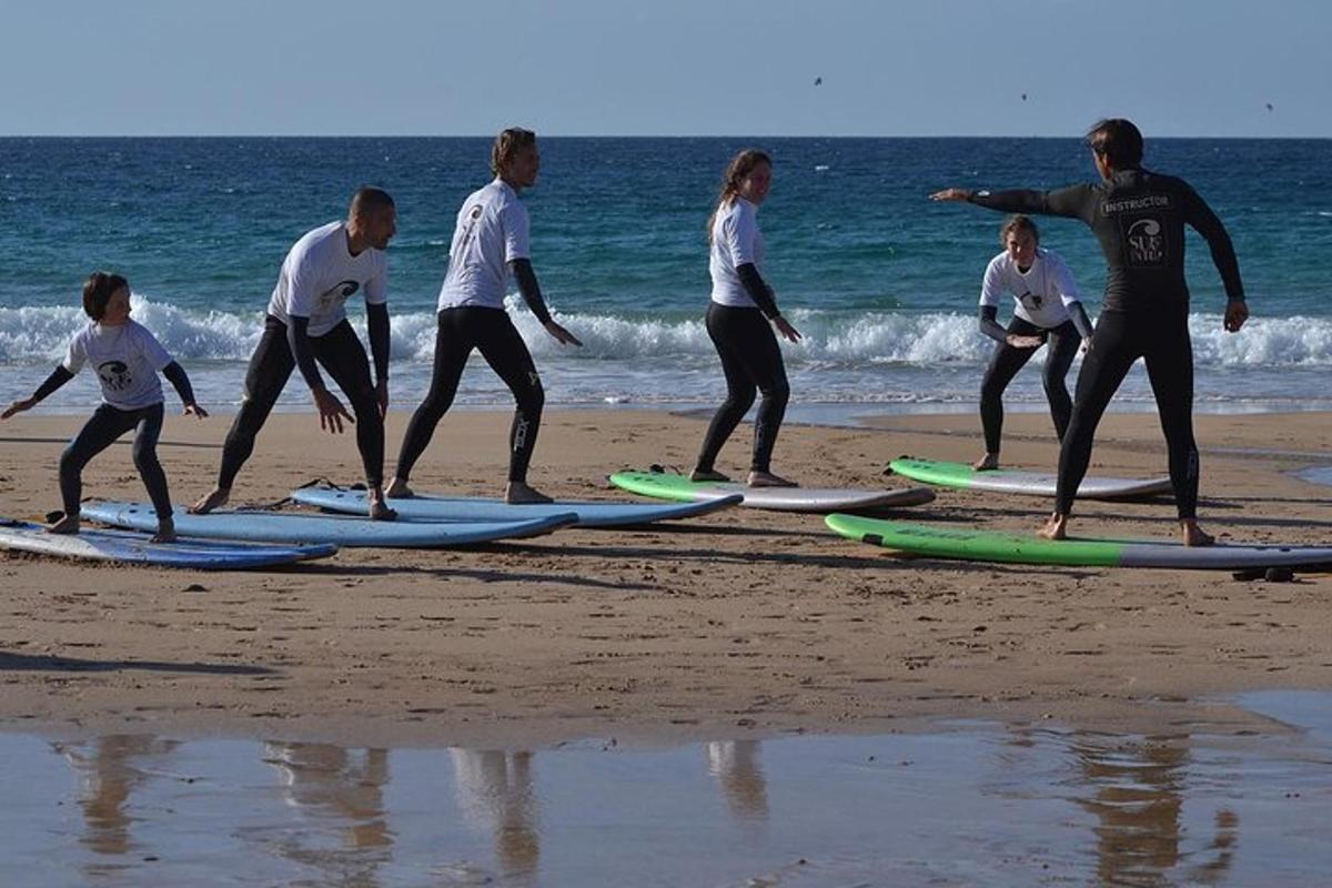 um grupo de pessoas em pé em pranchas de surfe na praia