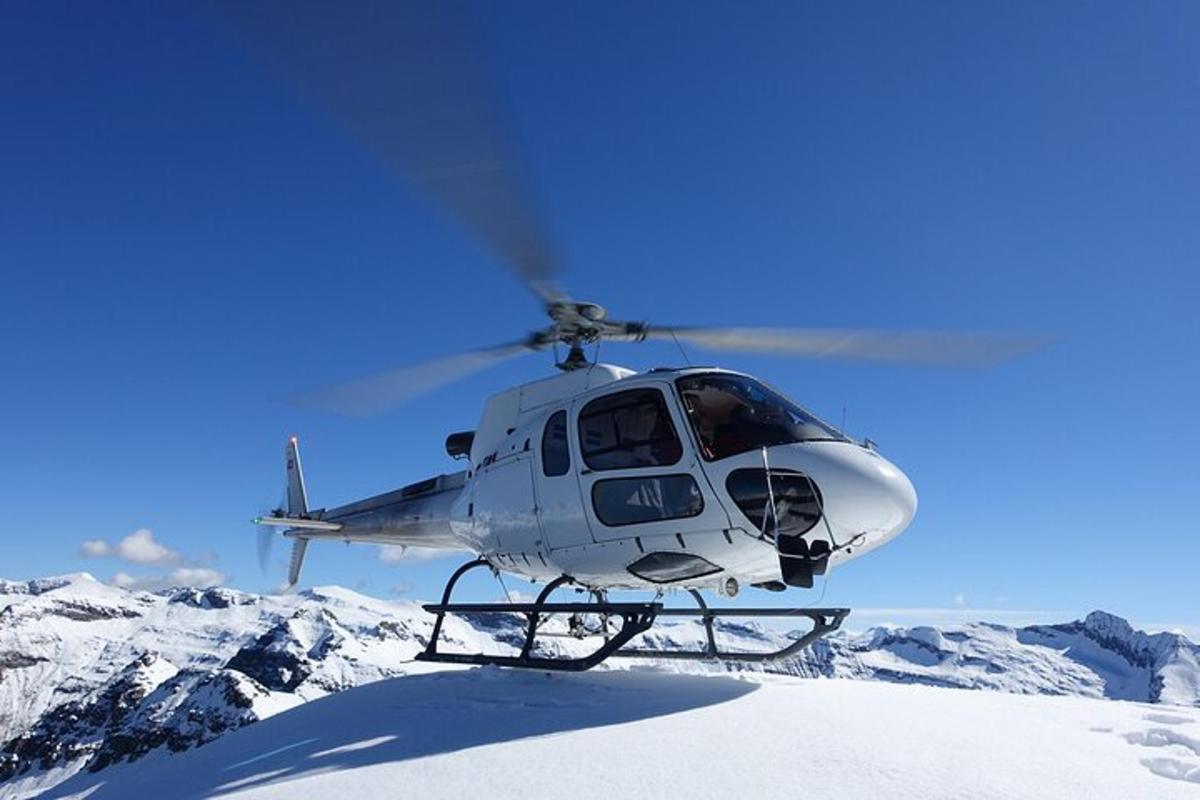 helikopter leci nad ośnieżoną górą