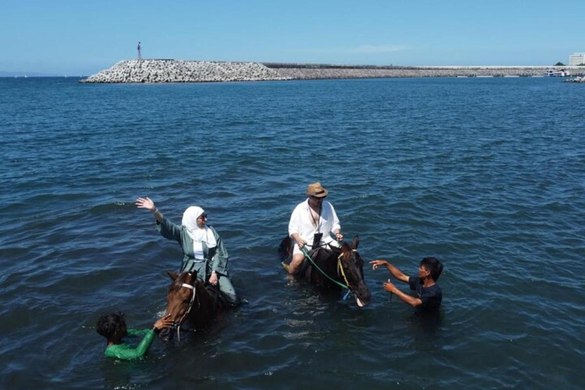 Un grupo de personas montando a caballo en el agua.