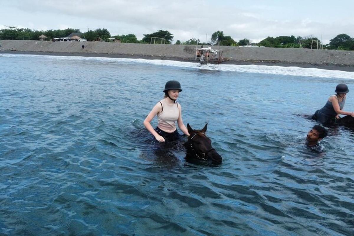 una mujer sentada en un caballo en el agua