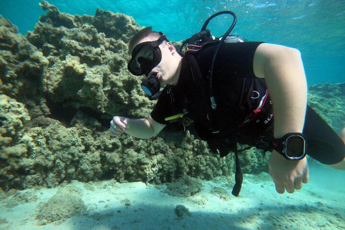 Muž v potápěčském obleku plave v oceánu