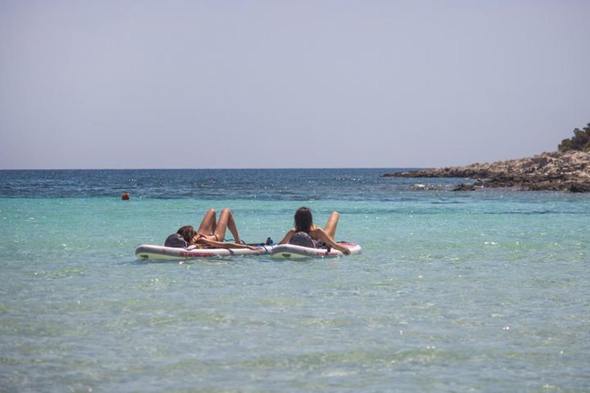 due ragazze sdraiate su una zattera in acqua