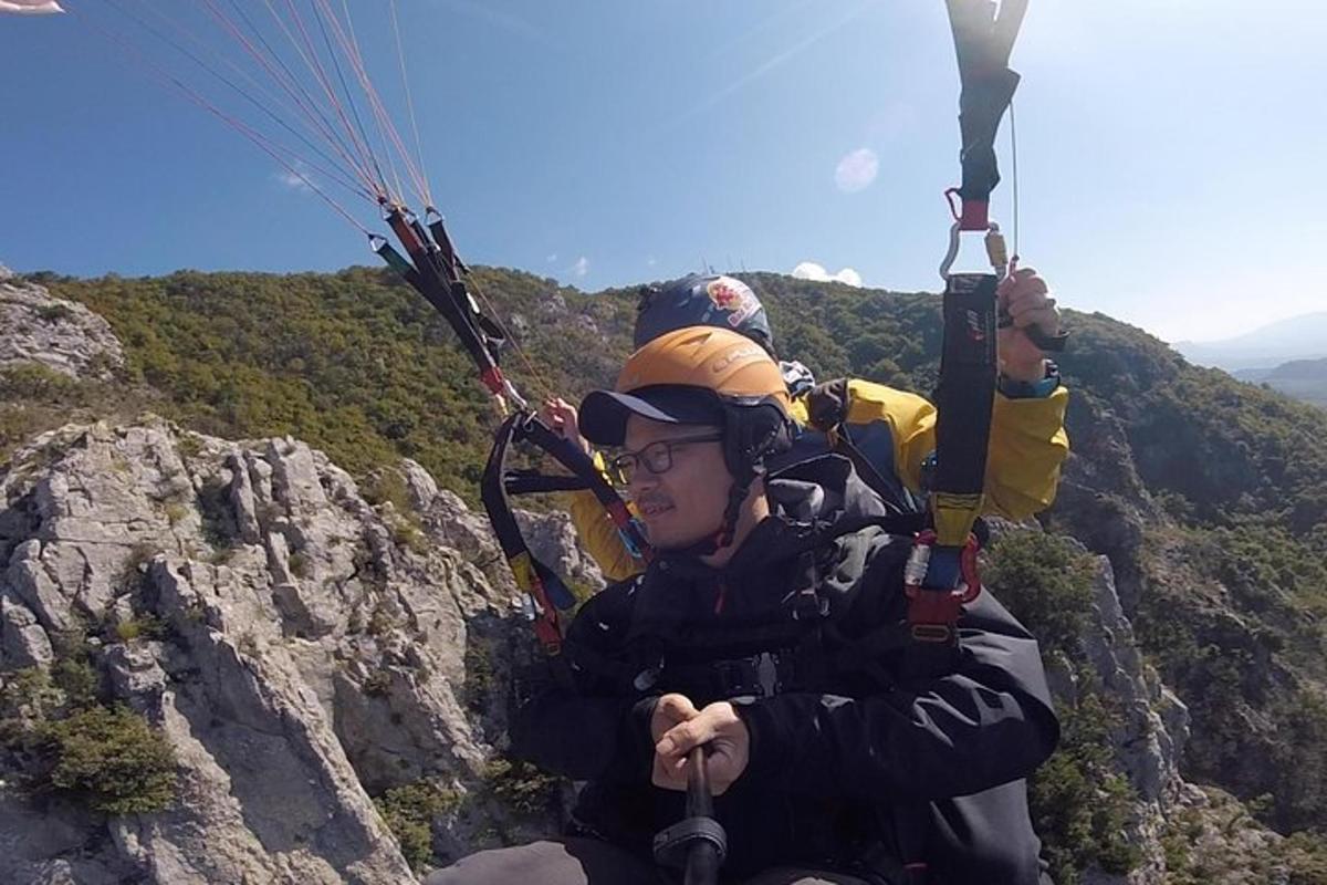 um homem andando de paraquedas no topo de uma montanha