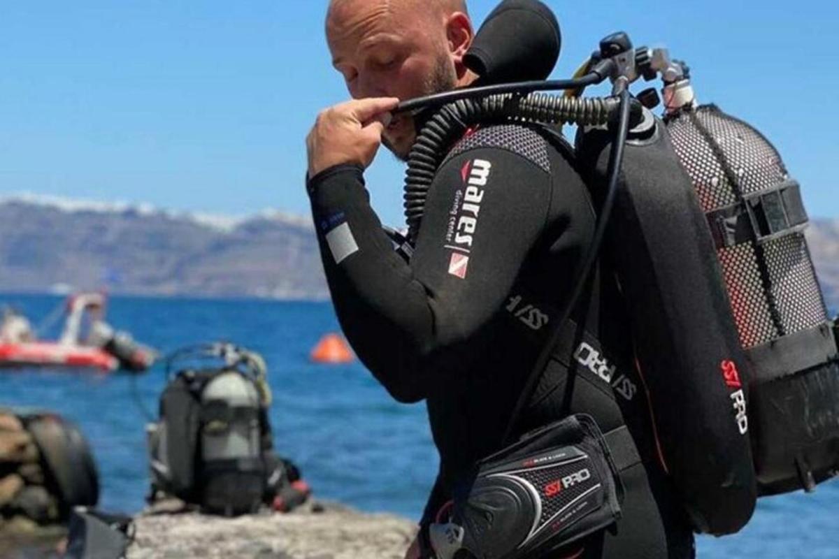 muž v potápěčském obleku držící fotoaparát