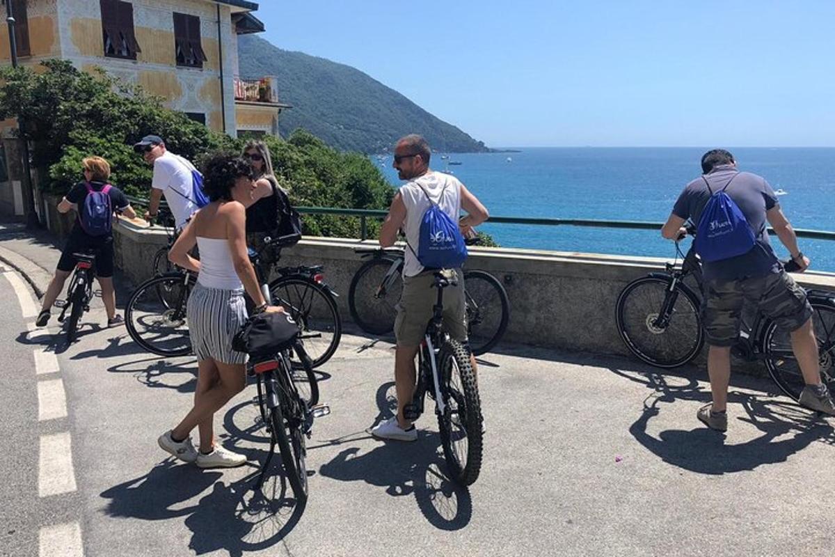 a group of people riding bikes on a sidewalk near the ocean
