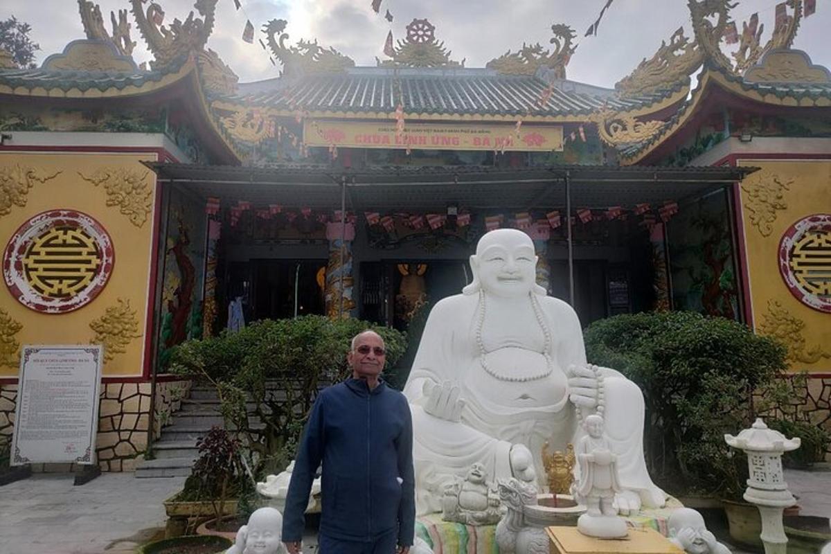 un uomo in piedi davanti a una grande statua
